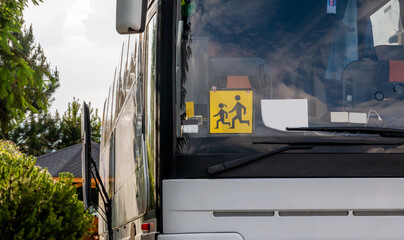 Single empty modern school trip bus, kids transport designated coach vehicle detail, closeup,...