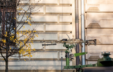 One single simple machine gun on top of a military vehicle in the city, detail, closeup, nobody. War and warfare abstract concept, weapons, weaponry, car gun mount, no people