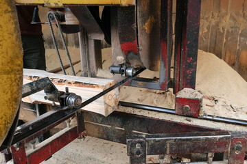 A sawmill cuts a tree trunk into planks. Processing wooden boards at a sawmill