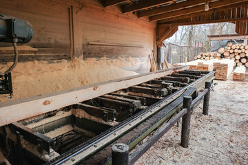 Sawmill. Industrial sawing of boards from logs on a sawmill. Timber industry.