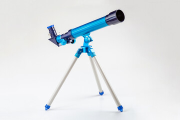 Blue toy telescope on a tripod, single object isolated on white background. Stargazing, space...