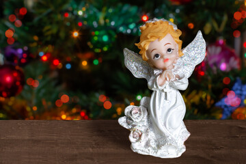 figurine of an angel in white on the background of a christmas tree copy space