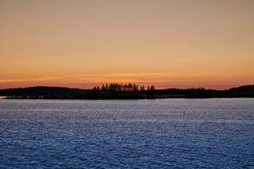 Russia. Onega lip of the White Sea. The sun went over the horizon behind the forest