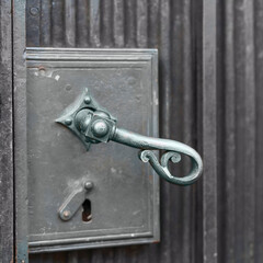 vintage metal door handle on a metal door close up