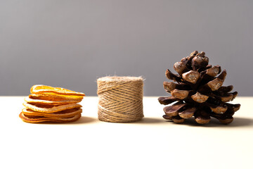 Stone pine cone (Pinus pinea), dried tangerine slices and a skein of string. Side view. Christmas...