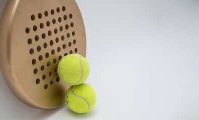 a paddle racket with two balls on a white background.