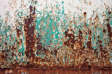 Wide rusty metal or steel surface with shabby green and white paint