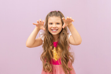 A little girl with curly hair is trying to scare.