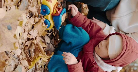 Vertical Portrait - Small child plays with his mother in the autumn forest. The concept of childhood, happy family and lifestyle. Nature, clean air, active rest on weekends - Powered by Adobe