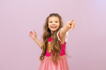A little beautiful girl with curly hair shows her hand forward