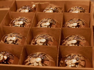 Golden Christmas balls in a paperboard box as background.