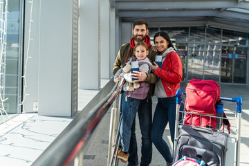 Family with little kid in airport terminal. Traveling by airplane during the vacation. Adventures...