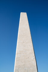 Fototapeta na wymiar Panoramic view of the marble granite obelisk, an ancient monument made of stone. Minimalist frame of architecture.