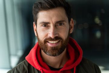 Fototapeta premium Portrait view of the caucasian unshaven man looking at the camera while standing at the airport. He feeling great before his voyage