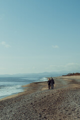 An embraced couple strolling on the beach