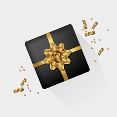 Black gift box with shiny yellow ribbon, bow and confetti particles.