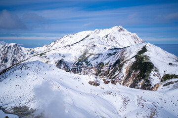 Fototapeta premium 富山県立山町にある立山の冬の雪景色のある風景 Landscape with snowy winter scenery of Tateyama in Tateyama Town, Toyama Prefecture, Japan.