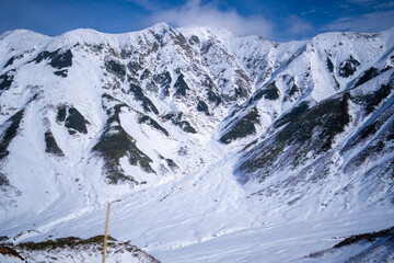 Fototapeta premium 富山県立山町にある立山の冬の雪景色のある風景 Landscape with snowy winter scenery of Tateyama in Tateyama Town, Toyama Prefecture, Japan.