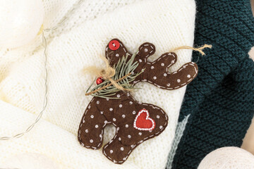 Brown deer on white sweater, led lights. Christmas decoration on the snow. Christmas card	