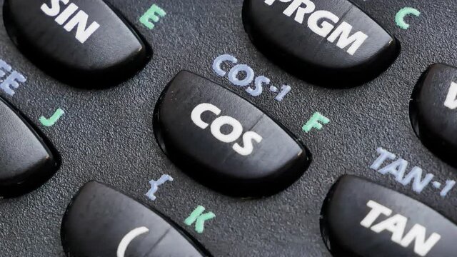 Finger pressing a cos, cosinus function button on a modern scientific calculator device, detail, macro, extreme closeup. Mathematical geometric functions and features abstract math symbols concept