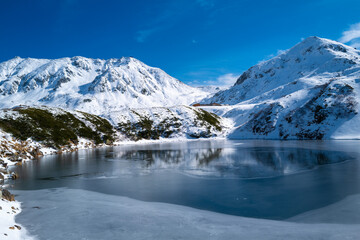 Fototapeta premium 富山県立山町にある立山の冬の雪景色のある風景 Landscape with snowy winter scenery of Tateyama in Tateyama Town, Toyama Prefecture, Japan.
