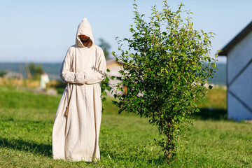 Summer, 2018 - Ussuriysk, Russia - Military-historical reconstruction of the old Russian army. An old Russian pagan monk in a white robe stands in a field. - obrazy, fototapety, plakaty