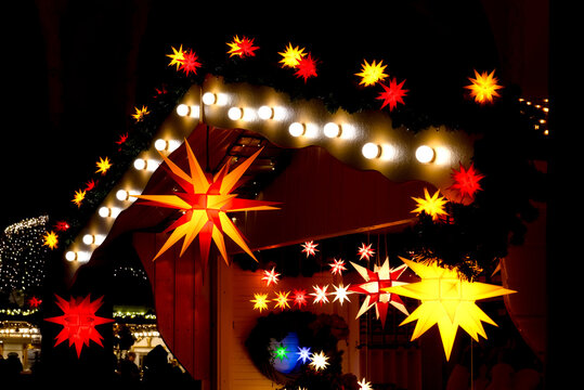 Red, yellow and orange Moravian stars (German: Herrnhuter Sterne) on a  stand at the Koblenzer Christmas market