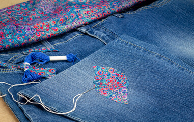Visible mending on jeans, creative sustainable fashion, repair, mend and recycle. slow fashion make...