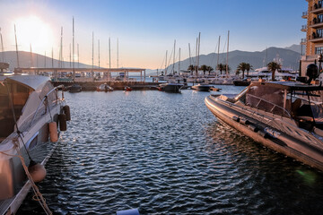 Yachts and boats on the pier of the city of Tivat, Montenegro, the Balkans, the Bay of Kotor, the Adriatic Sea. Mountains and sunset.