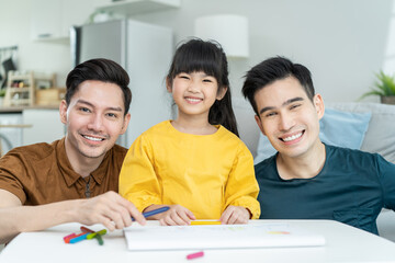 Portrait of handsome man gay family with young daughter in living room. 