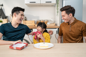 Asian attractive LGBTQ gay family celebrate birthday girl kid in house. 
