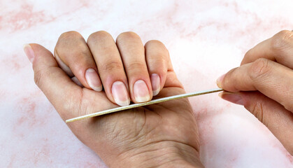 Woman filing her nails - manicure