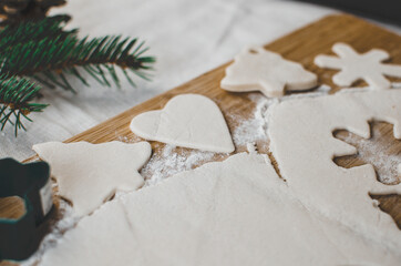 White, salt dough, homemade Christmas tree ornaments in the shape of trees, hearts and snowflakes.