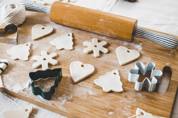 White, salt dough, homemade Christmas tree ornaments in the shape of trees, hearts and snowflakes.