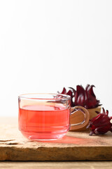 Fresh roselle flower tea in cup glass on wooden with white background (Hibiscus sabdariffa), Herbal medicine for reduction in blood pressure