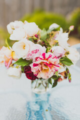 close-up of bunch of rose flowers in vase on top of outdoor table