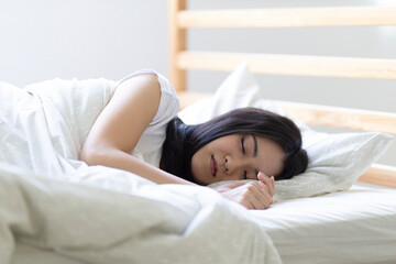 Fototapeta na wymiar ベッドで寝る女性