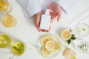 Lemon extract with sliced lemon transparent podium , petri dish in a white background , green leaf  in a test tube and doctor for cosmetic jar advertising , photography science concept