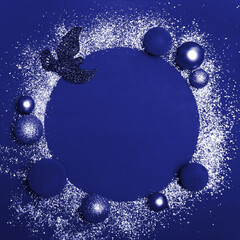 Christmas card background, on a dark blue background white glitter and Christmas toys in the form of a round frame