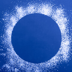 Christmas card background, on a dark blue background white glitter in the form of a round frame
