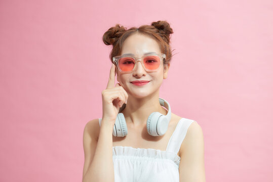 Photo of young woman happy positive smile hand touch sunglass cool isolated over pink color background