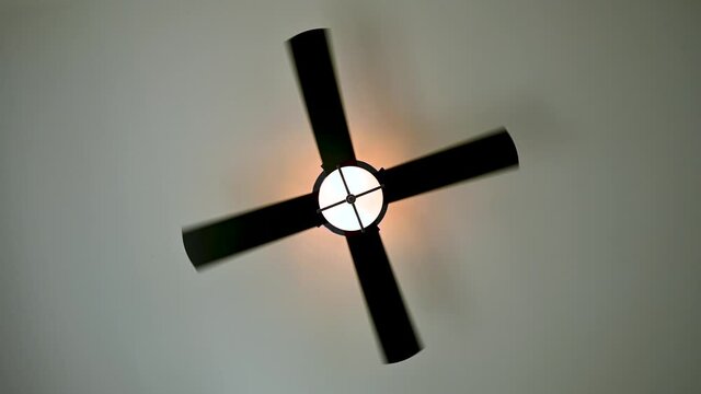 Ceiling fan spinning on low speed with light on
