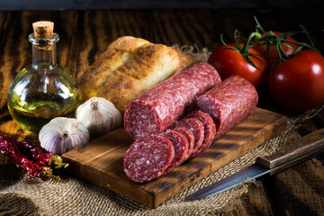 salami on a cutting board with slices. - obrazy, fototapety, plakaty