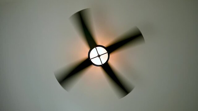 Ceiling fan spinning on high speed with light on