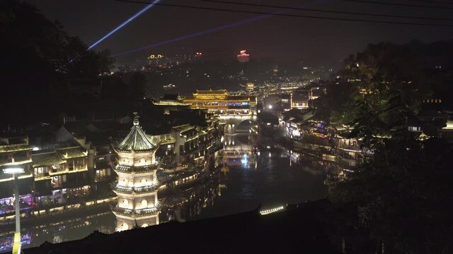 Night View Of Fenghuang Wanming Pagoda On The Bank Of Tuojiang River With Traditional Riverside Wooden Houses In Fenghuang Ancient Town In China. static