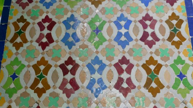 This close up video shows a tilt of colorful moroccan tiles motifs on a wall.