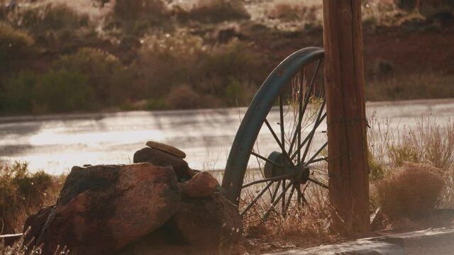 shot of a wheel of an old western covered wagon in the early morning light with a slight breeze in 4k.