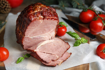 Delicious ham with tomatoes and basil on parchment, closeup. Christmas dinner