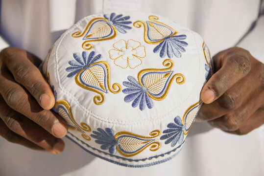 Muslim man holding an embroidered hat in his hands on a celebration day
