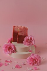 Rose soap. Beauty and aromatherapy. Flower soap. Pink soap bars and pink roses on podium on pink background.Organic Rose Soap with Rose extract .Organic cosmetics.